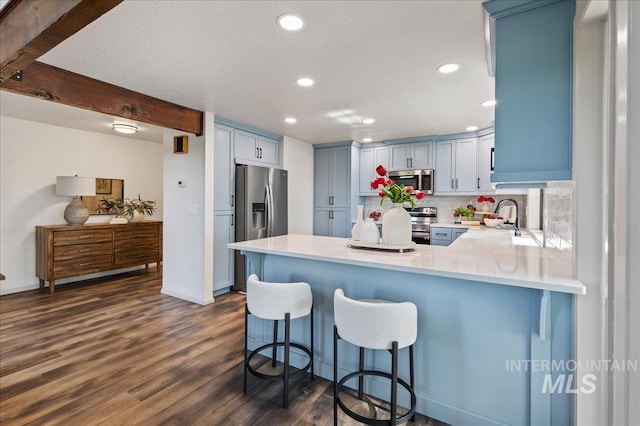 1909 E Roanoke Dr, Boise, ID 83712 - kitchen with appliances with stainless steel finishes, a peninsula, decorative backsplash, recessed lighting, and dark wood-style floors