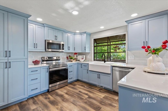 1909 E Roanoke Dr, Boise, ID 83712 - kitchen with appliances with stainless steel finishes, a sink, light countertops, recessed lighting, and backsplash