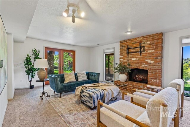 1909 E Roanoke Dr, Boise, ID 83712 - carpeted living area featuring a textured ceiling, a fireplace, french doors, and baseboards