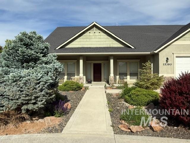 view of front of house with a shingled roof and stucco siding