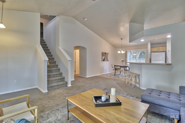 living area featuring lofted ceiling, stairway, carpet, and arched walkways