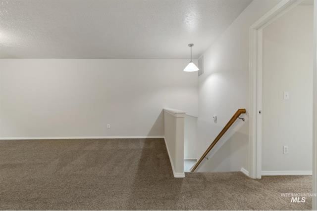 carpeted empty room featuring baseboards