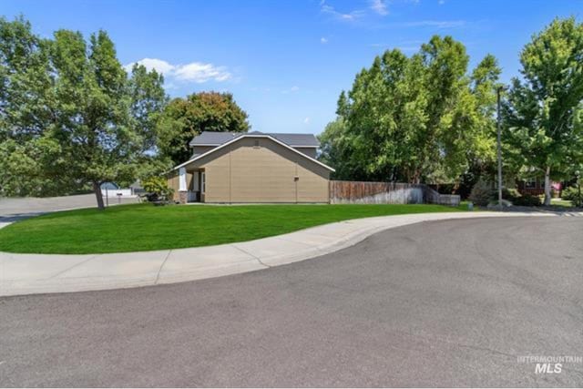 view of home's exterior with a lawn and fence