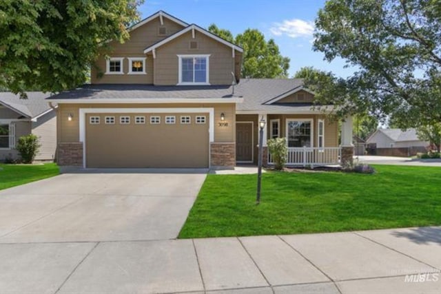 craftsman-style home featuring covered porch, an attached garage, driveway, and a front yard