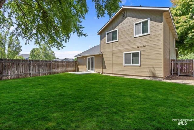 back of property with a yard and a fenced backyard