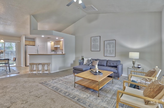 living room with baseboards, visible vents, high vaulted ceiling, ceiling fan, and light colored carpet