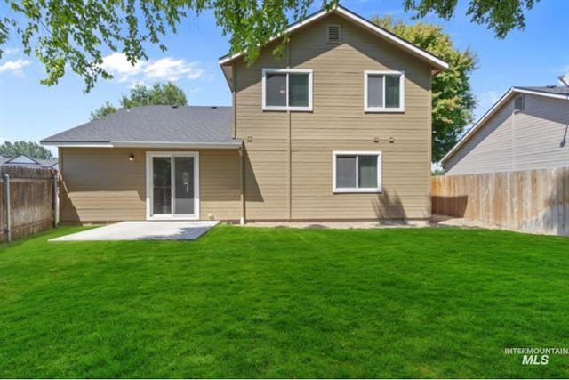 back of property with a patio area, a lawn, and a fenced backyard