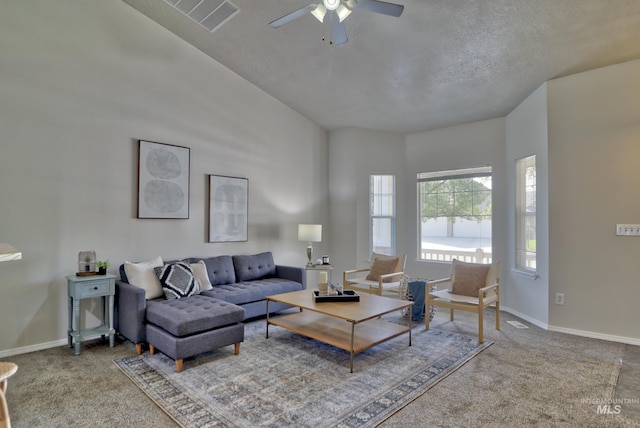 living area with carpet, visible vents, baseboards, ceiling fan, and a textured ceiling