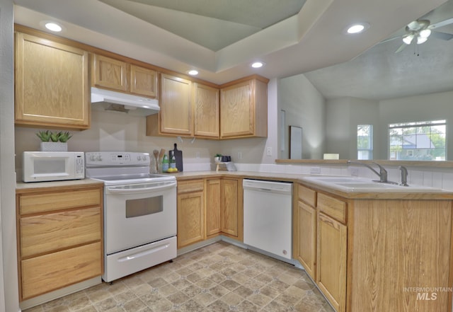 kitchen with under cabinet range hood, a sink, recessed lighting, white appliances, and a peninsula