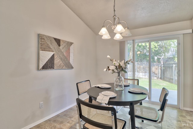 dining area with lofted ceiling, stone finish floor, a textured ceiling, baseboards, and a chandelier