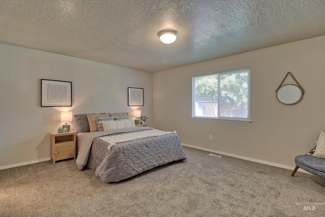 bedroom featuring visible vents, a textured ceiling, baseboards, and carpet floors