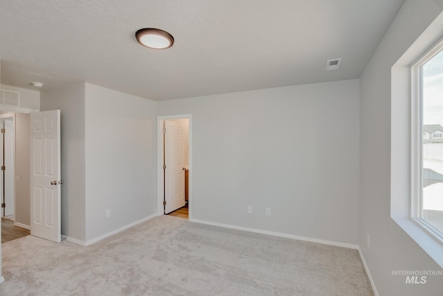 carpeted empty room with plenty of natural light