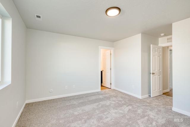 unfurnished bedroom with light colored carpet