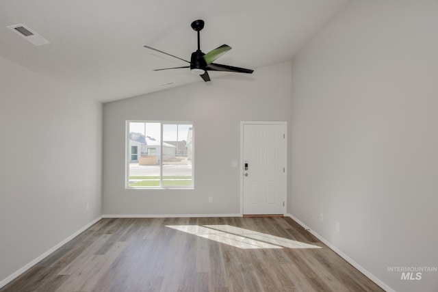 empty room with ceiling fan, lofted ceiling, and light wood-type flooring