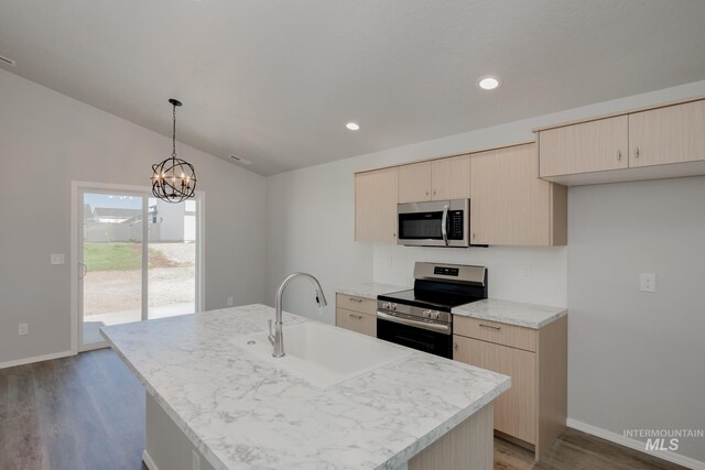 kitchen with an island with sink, appliances with stainless steel finishes, sink, and light brown cabinets