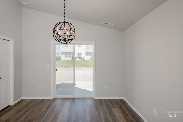 unfurnished dining area with a notable chandelier, vaulted ceiling, and dark hardwood / wood-style floors