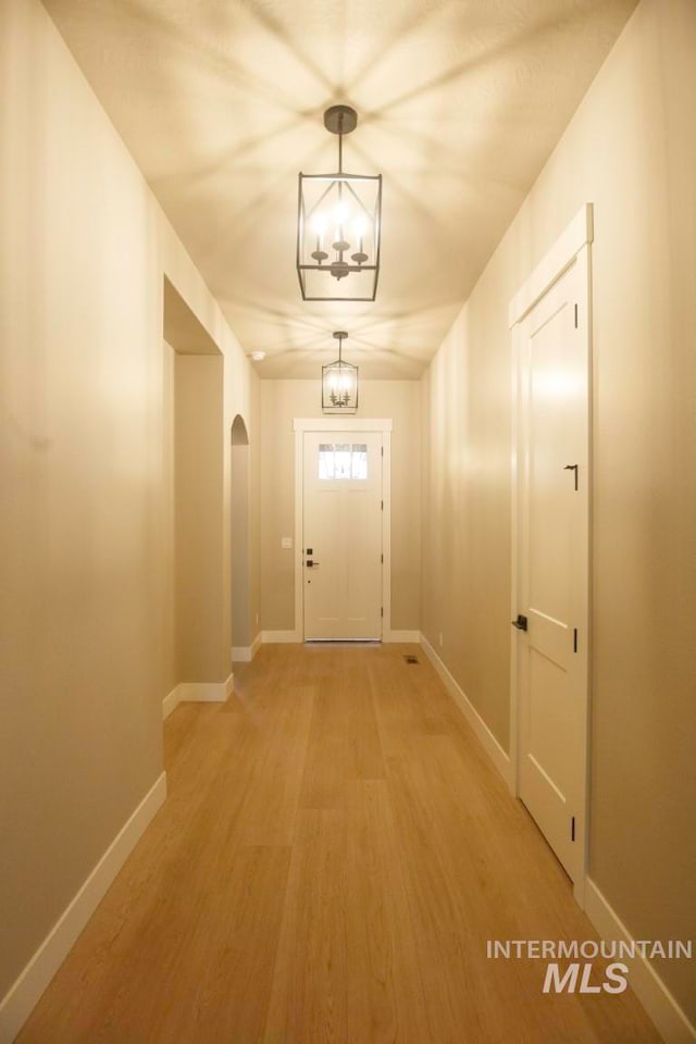 doorway featuring hardwood / wood-style floors and a notable chandelier