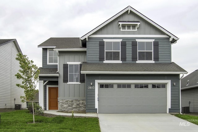 view of front of property featuring board and batten siding, a shingled roof, driveway, and a garage