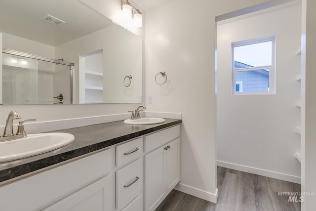 6847 W Riverwood St, Boise, ID 83709 - bathroom with a sink, a shower stall, wood finished floors, and visible vents
