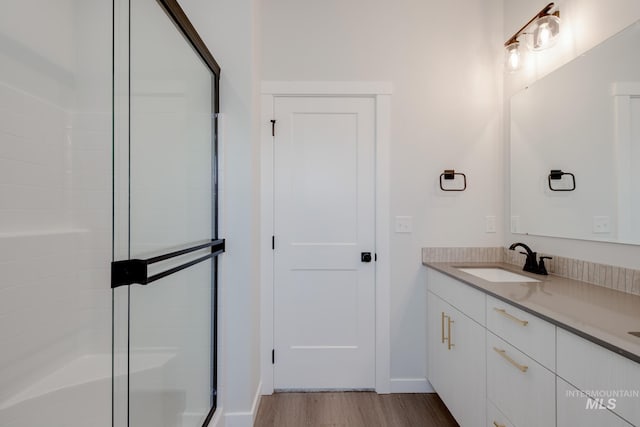6847 W Riverwood St, Boise, ID 83709 - bathroom featuring baseboards, wood finished floors, a shower stall, and vanity