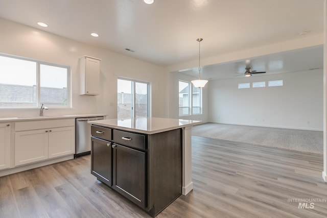 6847 W Riverwood St, Boise, ID 83709 - kitchen with light countertops, white cabinets, ceiling fan, dishwasher, and a sink