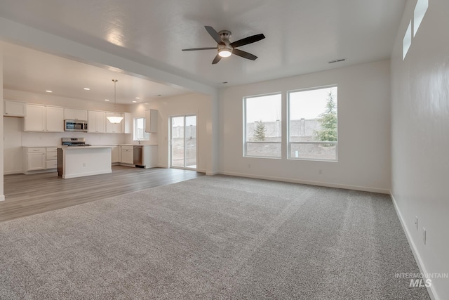 6847 W Riverwood St, Boise, ID 83709 - unfurnished living room featuring light colored carpet, ceiling fan, visible vents, baseboards, and recessed lighting