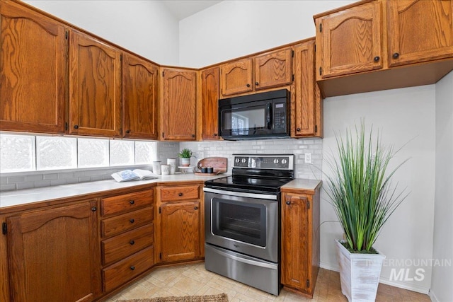 kitchen with black microwave, brown cabinetry, electric stove, and light countertops