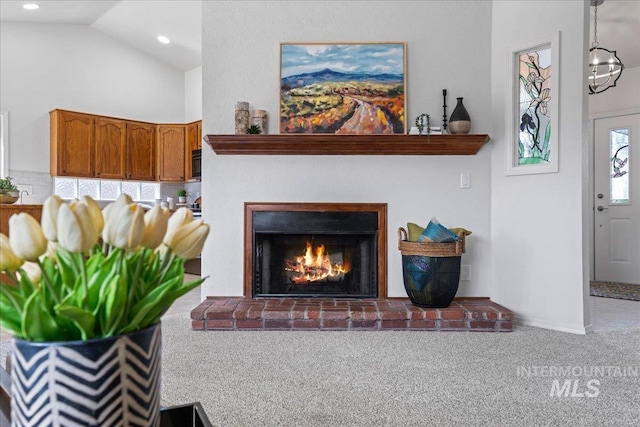 carpeted living area with high vaulted ceiling, a brick fireplace, and recessed lighting