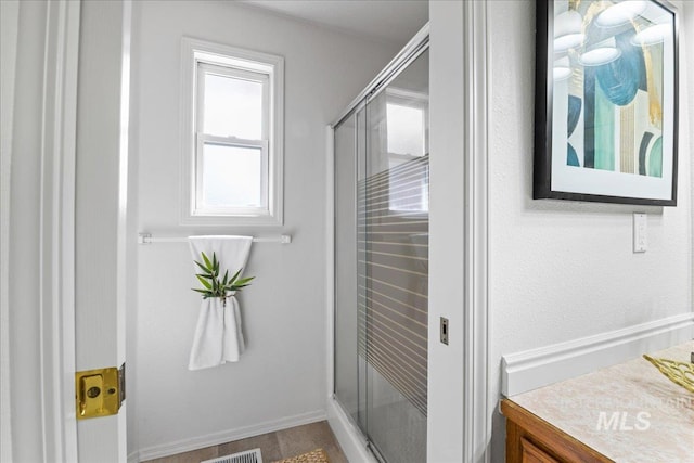 full bathroom with a stall shower, visible vents, and vanity