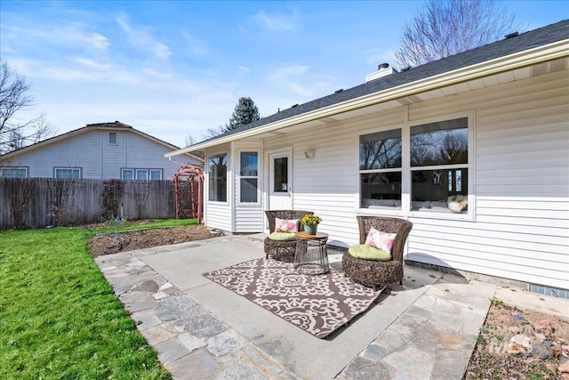 back of property with a lawn, fence, a chimney, and a patio