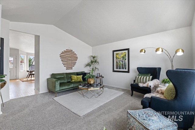 carpeted living area with vaulted ceiling