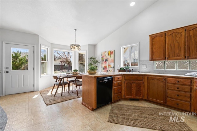 kitchen with dishwasher, a peninsula, light countertops, and brown cabinets