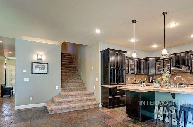 1878 W Sheep Hill Ct, Meridian, ID 83646 - kitchen with light countertops, under cabinet range hood, tasteful backsplash, glass insert cabinets, and recessed lighting