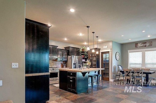 1878 W Sheep Hill Ct, Meridian, ID 83646 - kitchen featuring stainless steel appliances, light countertops, a kitchen bar, recessed lighting, and a kitchen island with sink
