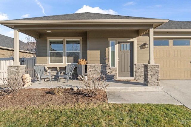 view of exterior entry featuring a patio area and a garage