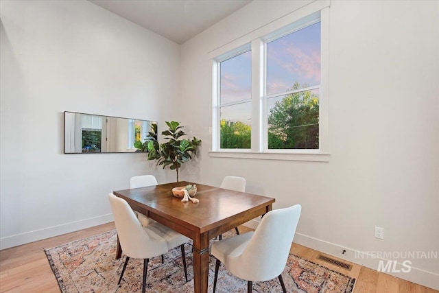 dining area with baseboards and wood finished floors