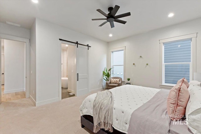 carpeted bedroom featuring a barn door, recessed lighting, baseboards, ensuite bathroom, and a ceiling fan
