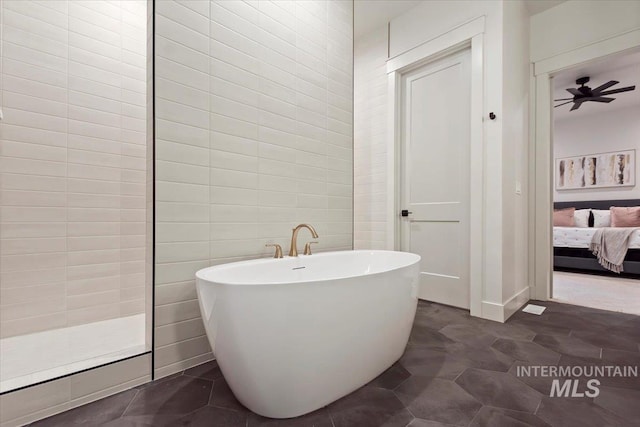 ensuite bathroom with a freestanding tub and a ceiling fan