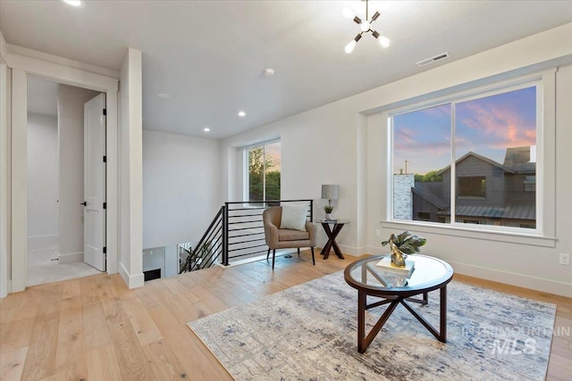 living area featuring an upstairs landing, wood finished floors, baseboards, and recessed lighting