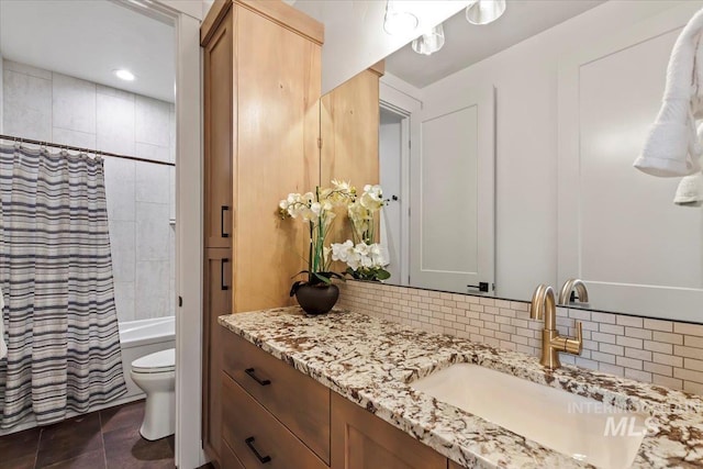 bathroom with vanity, toilet, shower / tub combo, and tasteful backsplash
