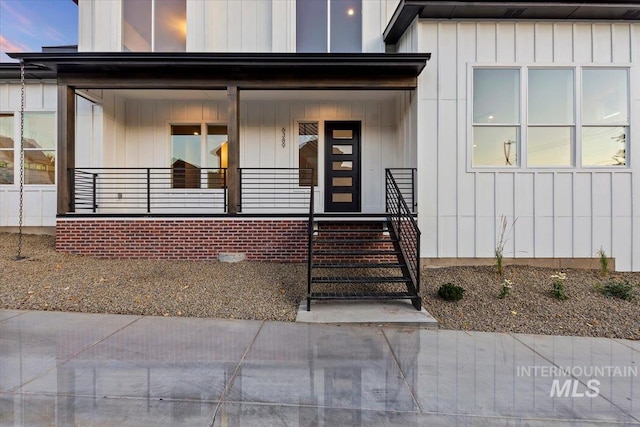 entrance to property with covered porch and board and batten siding