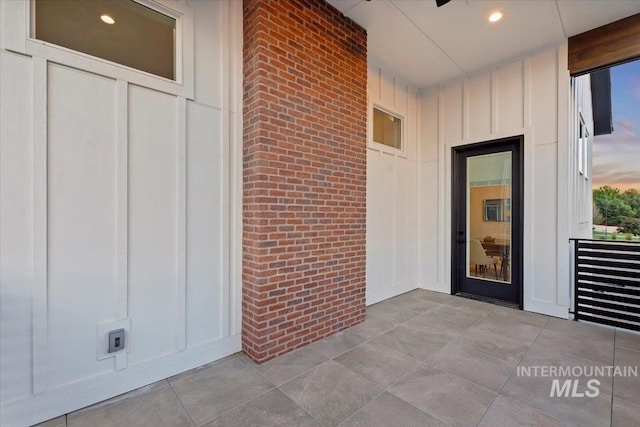 entrance to property with board and batten siding and brick siding