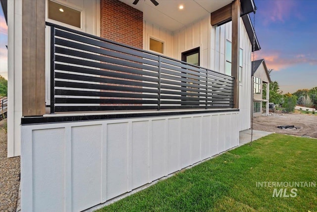 view of side of property with a balcony and a lawn