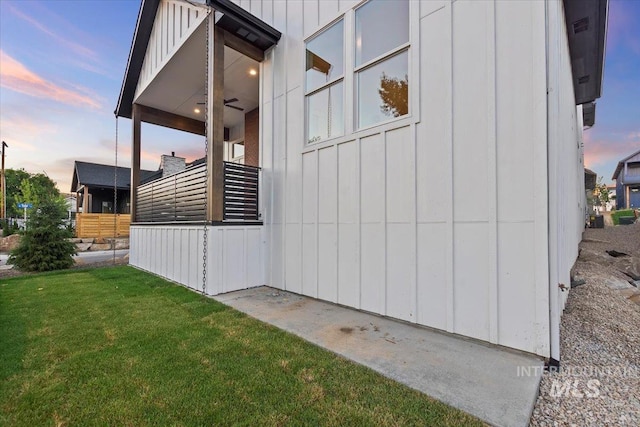 view of property exterior with board and batten siding and a yard