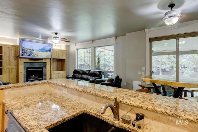 12507 N Humphreys Way, Boise, ID 83714 - kitchen featuring ceiling fan, a sink, a high end fireplace, open floor plan, and light stone countertops