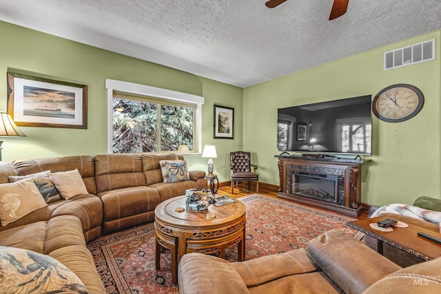 911 Davis, Mccall, ID 83638 - living room with a ceiling fan, a textured ceiling, wood finished floors, a glass covered fireplace, and baseboards