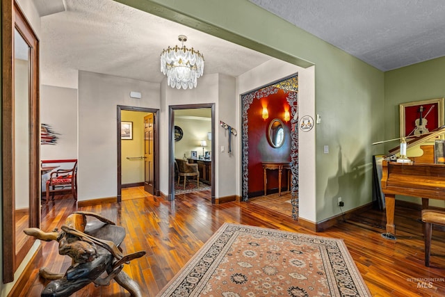 911 Davis, Mccall, ID 83638 - entryway featuring a textured ceiling, wood-type flooring, a chandelier, and baseboards