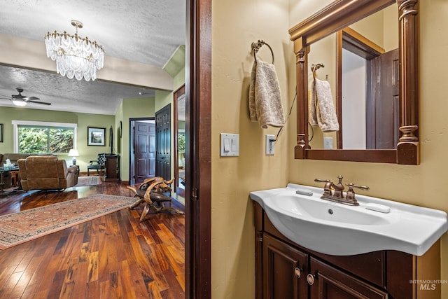 911 Davis, Mccall, ID 83638 - bathroom with a textured ceiling, hardwood / wood-style floors, vanity, ceiling fan, and a chandelier