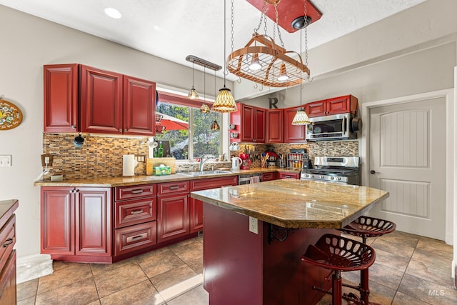 911 Davis, Mccall, ID 83638 - kitchen featuring stainless steel appliances, a sink, dark brown cabinets, decorative backsplash, and a breakfast bar