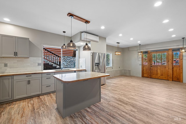 911 Davis, Mccall, ID 83638 - kitchen featuring stainless steel fridge, an AC wall unit, a sink, gray cabinets, and wood finished floors
